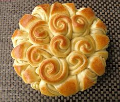 a pastry with spirals on it sitting on top of a woven tablecloth surface