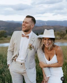 a man in a suit and tie standing next to a woman wearing a white dress