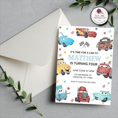 a birthday card with cars on it next to an envelope