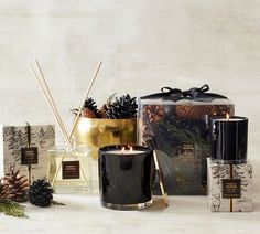 candles, pine cones and other decorative items are arranged on a table with a white background