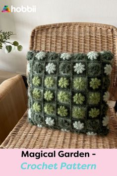 a crocheted pillow sitting on top of a wicker chair next to a potted plant