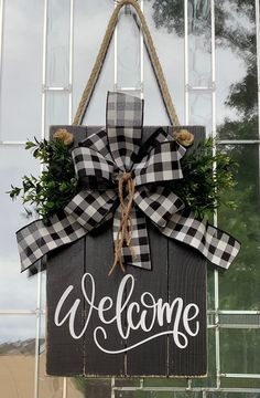 a welcome sign hanging from the side of a glass building with a bow on it