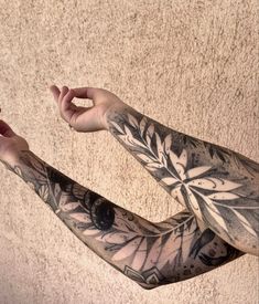 a man with tattoos on his arms holding a cell phone