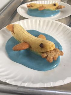 three paper plates with banana slices and chocolate chips on them in the shape of dogs