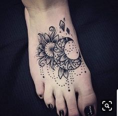 a woman's foot with a sun and moon tattoo on it