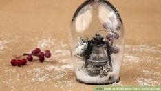 a glass bell jar filled with snow and berries