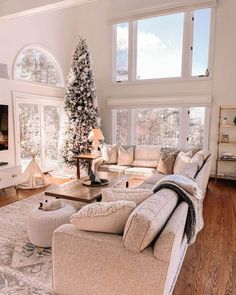 a living room filled with furniture and a christmas tree in the middle of the room