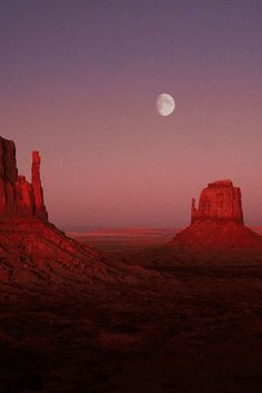 the moon is setting over monument buttes in monument national park