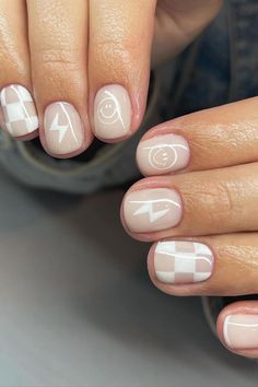 These short, rounded nails present a charming combination of playful designs on a sheer pink base. Simple white lines create an understated checked pattern, while whimsical white drawings infuse a touch of personality with lightning bolts and adorable smiley faces. The overall effect is a delightful medley of minimalistic and fun elements that’s perfect for adding a dash of lightheartedness to any look.  // Photo Credit: Instagram @nailsbyswayz Short Nail Designs With White, Nail Design Natural Nails Short, Short Nail Minimalist, Short Nails With Smiley Faces, Multi Color Manicure Ideas, While Nail Ideas, Simple Nails Smiley Face, Fun Cute Nail Designs, Simple Nail Designs On Short Nails