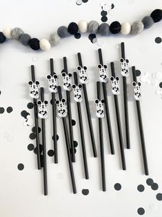 black and white paper straws with mickey mouse faces on them are lined up in a row