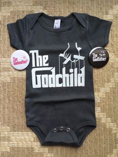 a black bodysuit with the words the godchild on it and a button in front