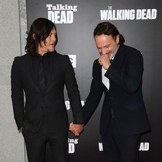 two men in suits holding hands at the walking dead premiere