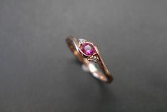 two gold rings with pink sapphires and diamonds on the sides, one in white gold