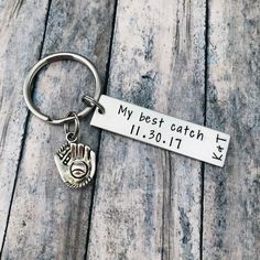 a metal keychain with a hand holding a heart and the words my best catch on it