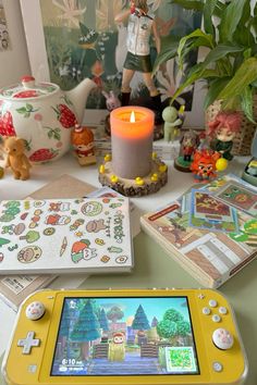 a yellow nintendo wii game system sitting on top of a table next to a candle