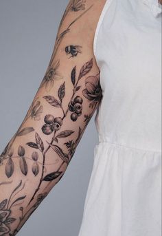 a woman's arm with flowers and butterflies on it