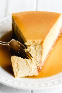 a piece of cheesecake on a white plate with a fork and caramel sauce