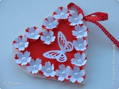 a heart shaped box with flowers and a butterfly on it