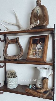 two wooden shelves with antlers and other items on them, one shelf is holding an empty vase