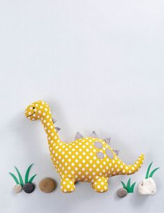 a yellow and white stuffed dinosaur with polka dots