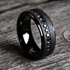 a black wedding ring with white diamonds on the inside and inlayed to it