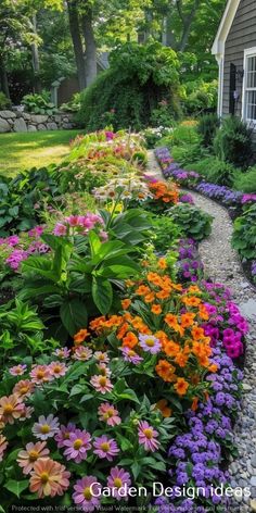 a garden with lots of colorful flowers in the front and side of it, next to a house