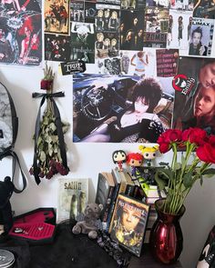 there are many pictures on the wall with flowers in vases next to it and other items