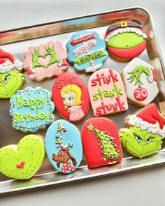 decorated cookies in the shape of grin's faces on a cookie sheet with happy birthday messages