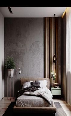 a large bed sitting in the middle of a bedroom next to a tall white wall