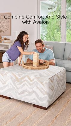 a man and woman sitting on top of a couch in front of a coffee table