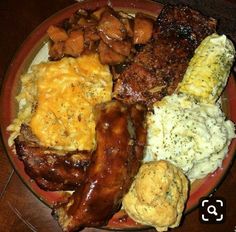 a red plate topped with meat, potatoes and gravy on top of a wooden table