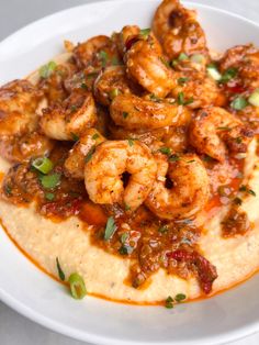 a white plate topped with grits and shrimp