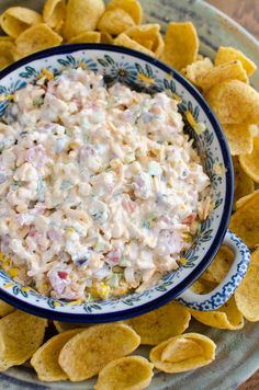 a bowl filled with dip surrounded by chips