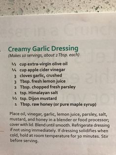 a recipe for creamy garlic dressing on a white counter top with green lettering and instructions