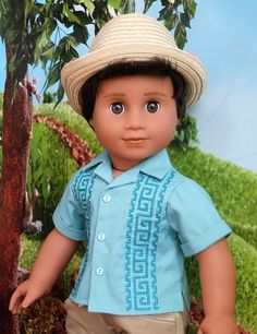 the doll is wearing a blue shirt and tan pants with a straw hat on his head