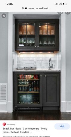 a kitchen with black cabinets and white walls