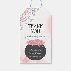 a baby shower gift tag with spider webs on the top and pink watercolor background