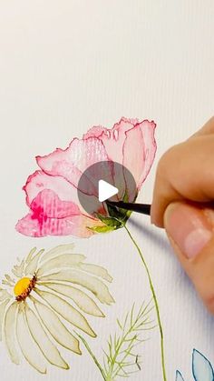 someone is painting flowers with watercolors on paper