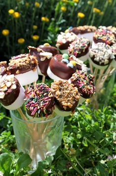 chocolate covered donuts with sprinkles and candies in a glass vase