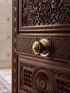 an ornate wooden door with brass handles and knobs on the handle is seen in this screenshot