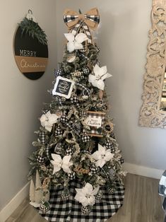 a christmas tree decorated with black and white plaid ribbon, bows, and pictures on it