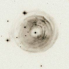 a black and white photo of the center of a circular object with stars around it