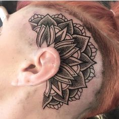 a close up of a person with a tattoo on their head and behind the ear