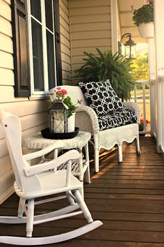 a porch with rocking chairs and potted plants on the front porch, next to a window