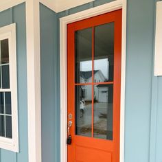 an orange front door on a blue house