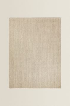 a beige square rug on a white wall