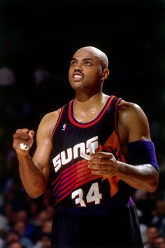 a basketball player holding a ball in his right hand and looking up at the sky