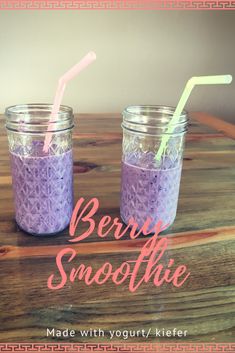 two mason jars filled with purple smoothie on top of a wooden table