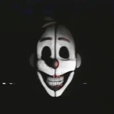 a person wearing a creepy mask in the dark