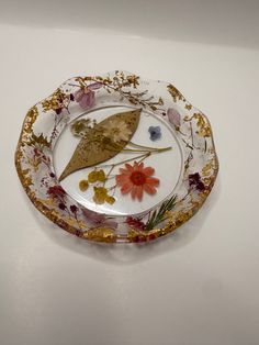 a decorative plate with flowers and leaves on it